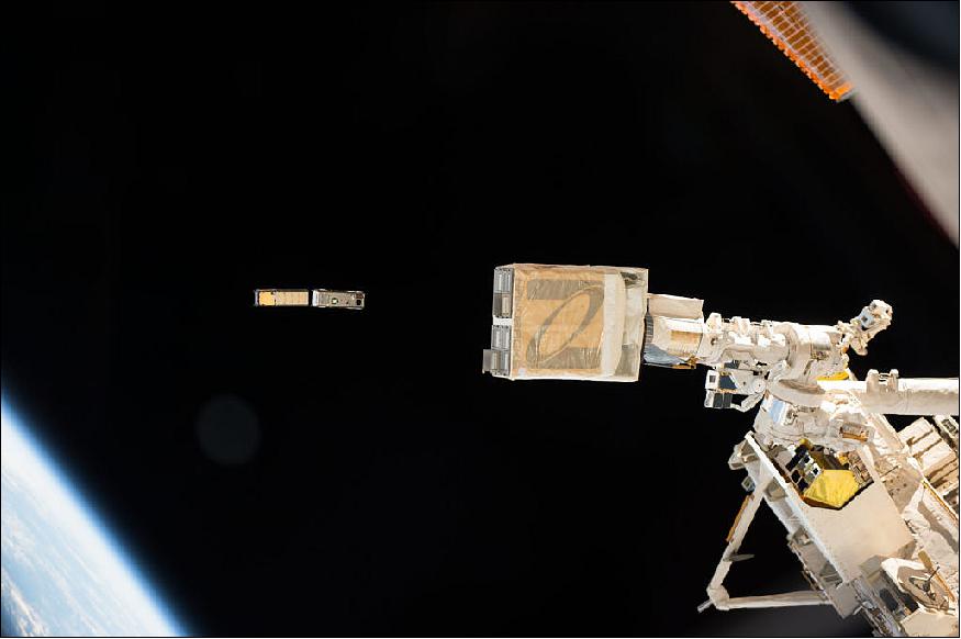 Photo taken by NASA astronaut Peggy Whitson from inside the International Space Station cupola: CXBN-2 (left) and IceCube cubesats are deployed by the NanoRacks deployer (foreground).